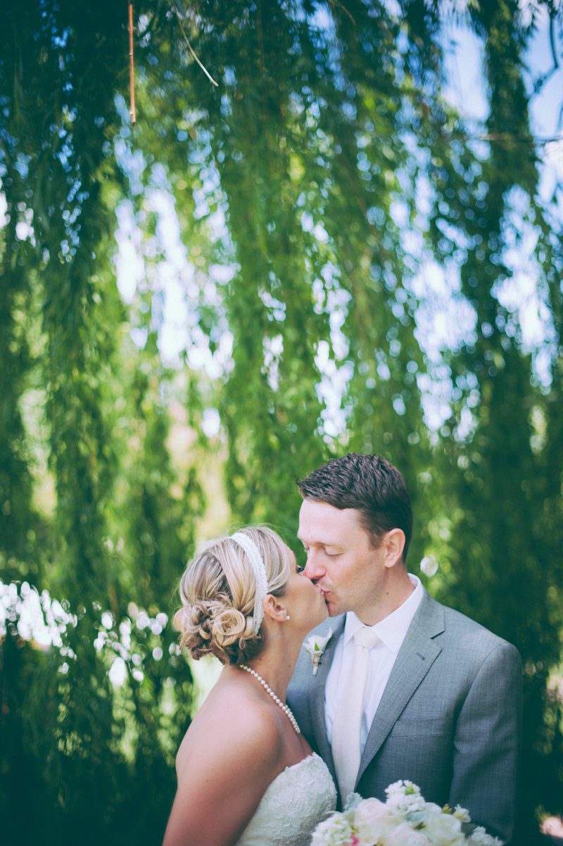 bride-and-groom-kissing-under-willow-tree