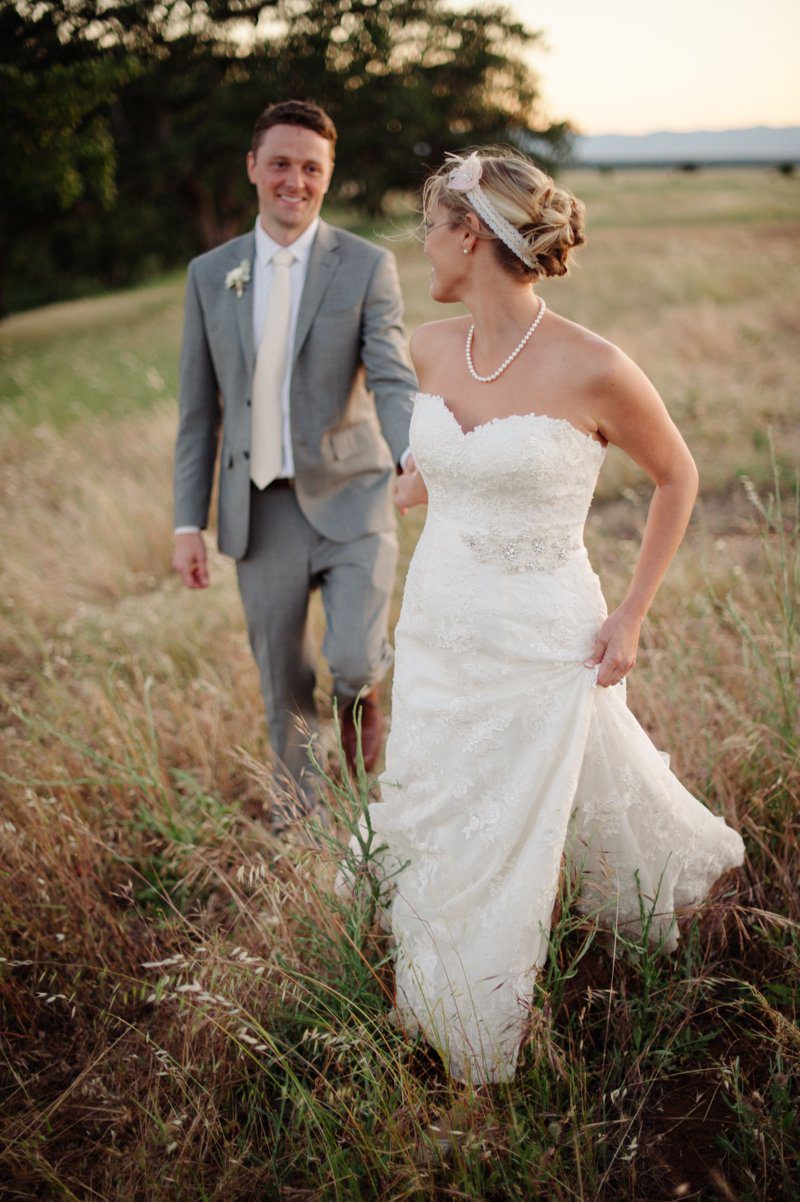 bride-walking-through-tall-grass-at-sunset